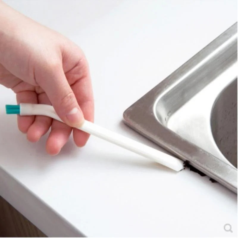 Long-handle cleaning brush reaching a bottle lid