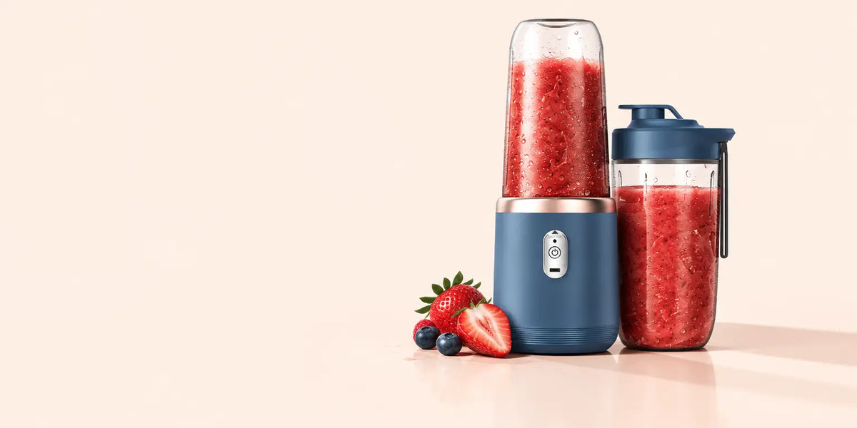 A studio photograph of the reference blue portable electric blender: compact blue motor base, clear